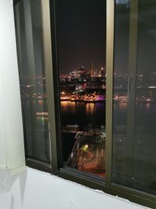 a window with a view of a city at night at Cloud9 hostel in Dubai