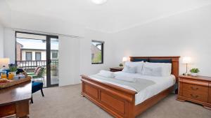 a bedroom with a large bed with a desk and a desk at Bluebell in Bowral