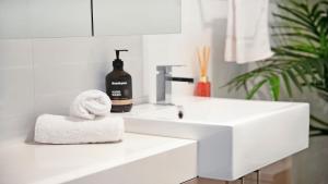 a white bathroom with a sink and a towel at Bluebell in Bowral +16 photos