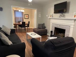 a living room with a couch and a fireplace at Comfort by The University & Waterfront in Elizabeth City