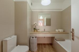 a bathroom with a sink and a toilet and a mirror at Elegant 3 bedroom apt - City centre - garage - metro in Lisbon +61 photos