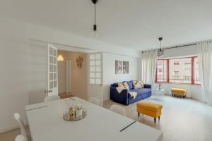 a living room with a blue couch and a table at Elegant 3 bedroom apt - City centre - garage - metro in Lisbon