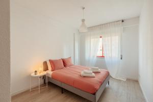 um quarto com uma cama com lençóis laranja e uma janela em Elegant 3 bedroom apt - City centre - garage - metro em Lisboa