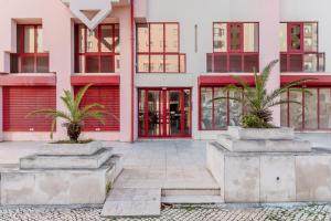 a pink building with palm trees in front of it at Elegant 3 bedroom apt - City centre - garage - metro in Lisbon