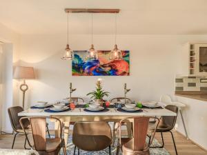 tavolo da pranzo con sedie e dipinto sul muro di Marram Dune Beach House a Brean