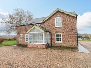 a red brick house with a large window at Foreman's House in Rudston