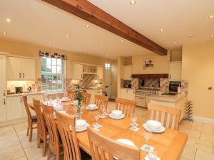 uma cozinha e sala de jantar com uma mesa de madeira e cadeiras em Foreman's House em Rudston