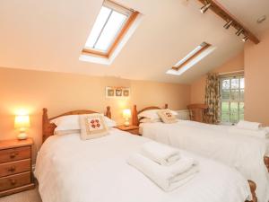 two beds in a room with two windows and skylights at Foreman's House in Rudston