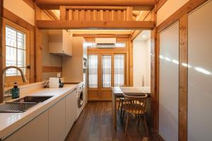 a kitchen with a sink and a table with chairs at Luxury hanok with private bathtub - SN09 in Seoul