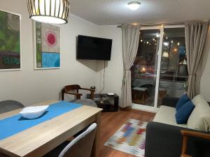 sala de estar con mesa y sofá en Departamento Marina Peñuelas, en La Serena