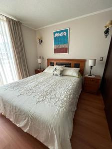 Un dormitorio con una cama grande y una ventana en Departamento Marina Peñuelas, en La Serena