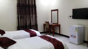 um quarto de hotel com duas camas e uma televisão de ecrã plano em Hana Yanbu Hotel Apartments em Iambo