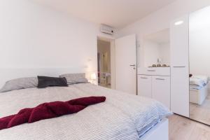 biała sypialnia z dużym łóżkiem i łazienką w obiekcie Apartment Losacker w mieście Vir