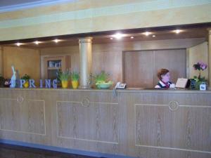 Eine Frau sitzt an einem Tresen in einer Hotellobby in der Unterkunft Hotel Gerber in Hösbach