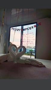 uma cama com um cisne branco em frente a uma janela em Cabañas ian em San Antonio del Tequendama