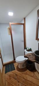 a bathroom with a toilet and a wooden floor at Mariposa - Cabañas Puerto del Zopilote in Pinal de Amoles
