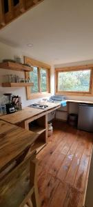 a kitchen with wooden floors and a counter and windows at Mariposa - Cabañas Puerto del Zopilote in Pinal de Amoles