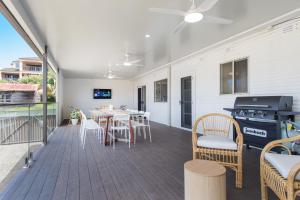 un patio avec une table, des chaises et un grill dans l'établissement Lazy Stays, à Port Macquarie