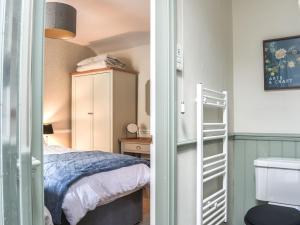 Dormitorio pequeño con cama y armario en Primrose Cottage, en Grassington