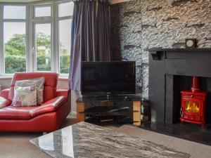 a living room with a tv and a fireplace at Westville in Criccieth