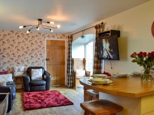 a living room with a dining room table and a living room at The Stables - Uk41958 in Laurieston