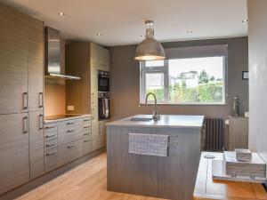 a kitchen with a sink and a large window at Westville in Criccieth