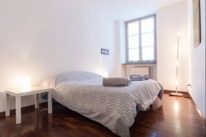 Schlafzimmer mit einem Bett, einem Tisch und einem Fenster in der Unterkunft De Lellis in Turin