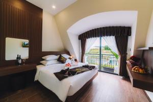 - une chambre avec un grand lit et une grande fenêtre dans l'établissement GREENECO DA LAT HOTEL - Khách sạn Green Eco Đà Lạt, à Đà Lạt