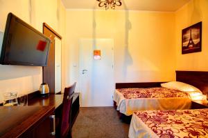 una camera d'albergo con due letti e una TV a schermo piatto di Hostel Evotel a Zielonka
