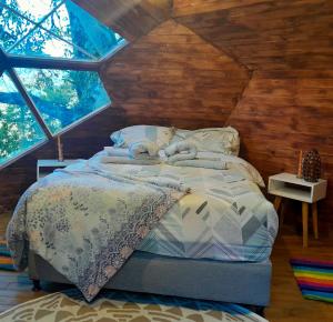 1 dormitorio con 1 cama en una casa en un árbol en Magno Glamping, en Boyacá