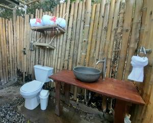 a bathroom with a toilet and a sink and a fence at Magno Glamping in Boyacá