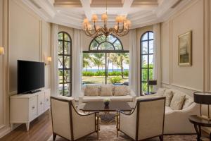 a living room with a couch and a tv and a table at Meliá Vinpearl Cam Ranh Beach Resort in Cam Ranh