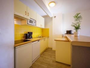 Kuchyňa alebo kuchynka v ubytovaní Appartement 10 personnes avec balcon à Peyragudes - 3 chambres, navette gratuite, casier skis - FR-1-695-18