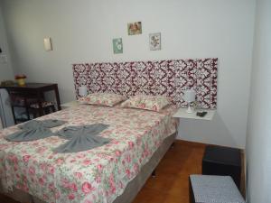 a bedroom with a large bed with a red headboard at Pousada Dona Esmeralda in São José do Barreiro