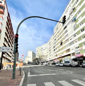 a traffic light on a city street with buildings at Cosy Apartment - lovely stay/ Free parking/ Netflix in Falagueira