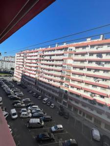 a parking lot with cars parked in front of a building at Cosy Apartment - lovely stay/ Free parking/ Netflix in Falagueira