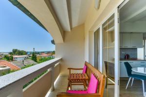 een balkon met een tafel en stoelen en een keuken bij Apartments Medved in Vir