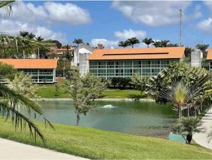 a building with a lake in front of it at Luxury Flat at Villa Hípica in Gravatá – PE | Locar House in Gravatá