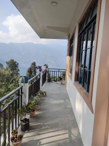 uma varanda com vista para as montanhas em Prakriti Homestay em Mangpu