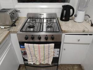 una cocina con fogones y una toalla en el horno en Dpto.2 habitaciones - 25 Mayo al 3000 en Mar del Plata