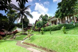une maison avec une cour herbeuse et un sentier dans l'établissement Bali Sesandan Garden, à Tabanan