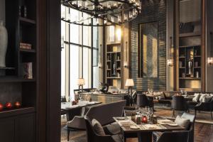 天津的住宿－天津四季酒店，餐厅设有桌椅和大窗户。