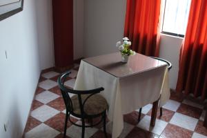 a table with a vase of flowers on it at Hotel Caribe Azul in Chancay