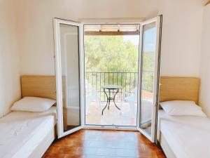 a room with two beds and a balcony with a table at Villa Elpiniki in Troulos
