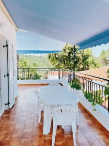 a white table on a balcony with a view of the ocean at Villa Elpiniki in Troulos