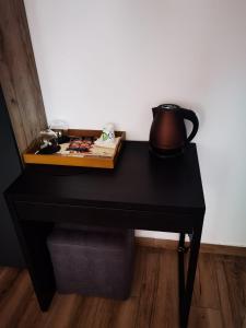 un tavolo nero con una teiera sopra di Pensiunea Doro a Călimăneşti
