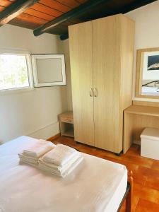 a bedroom with a white bed and a cabinet at Villa Elpiniki in Troulos