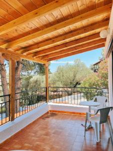 a porch with a wooden pergola and a table and chairs at Villa Elpiniki in Troulos