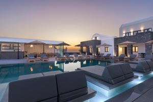 a swimming pool with lounge chairs and a resort at Onyx Hotel & Suites in Karterados