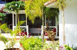 a garden with palm trees and plants in front of a house at The High Dive Gili Gede by Ultimate Resorts in Gili Gede